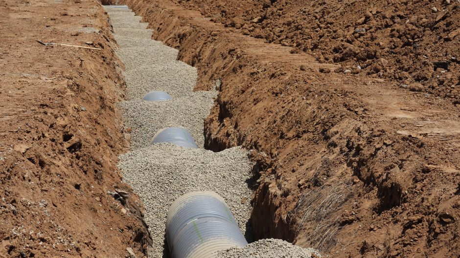 Underground drainage pipe installation protecting residential property