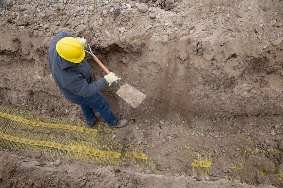 French drain installation in landscape area near patio