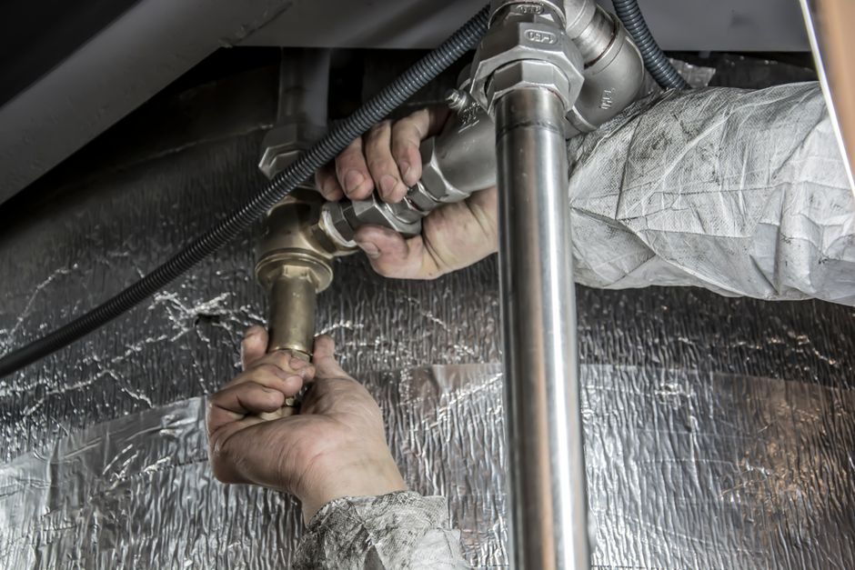 Plumber performing drain work in New Orleans bathroom